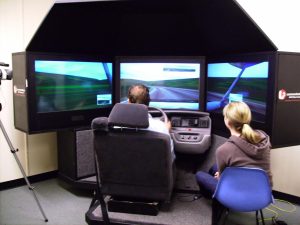 A student talks on a hands-free cell phone while operating a high-tech driving simulator. The simulator was used during a University of Utah study that found motorists who talk on cell phones while driving are as impaired as drunken drivers with blood-alcohol levels at the legal limit of 0.08 percent.